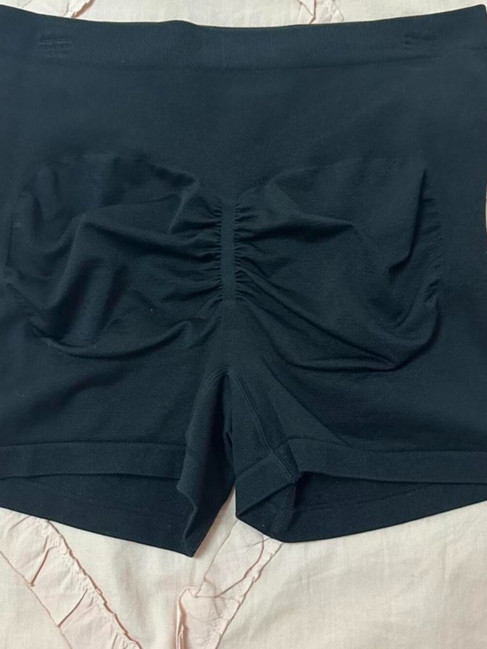 Black maternity workout shorts with ruched butt detail.